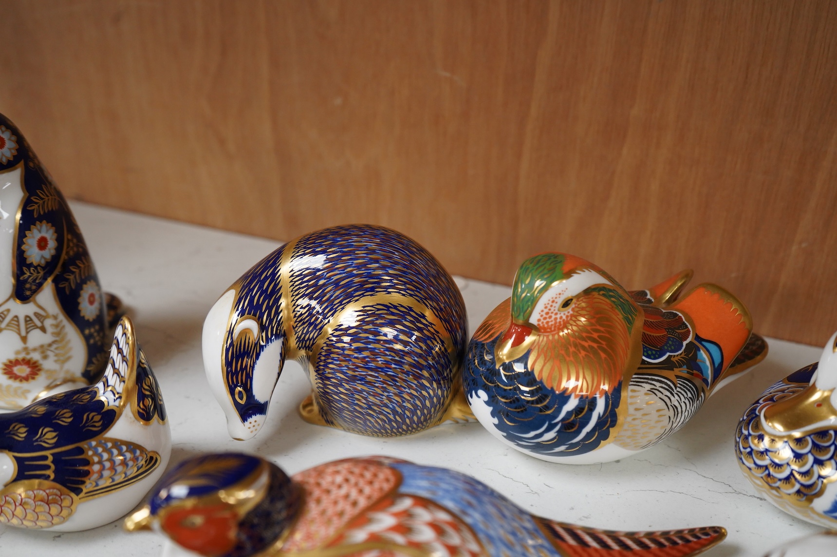 A collection of Royal Crown Derby Imari pattern paperweights, to include penguin and badger, together with three Doulton flambé animals, largest 19cm wide